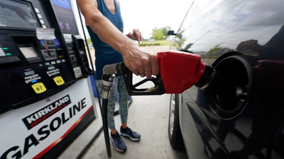 a customer readies to pump gas ap photo
